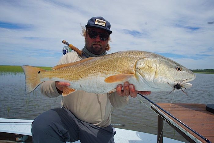 a man holding a giant red drum with his two hands