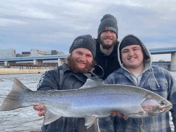 anglers holding a steelhead trout