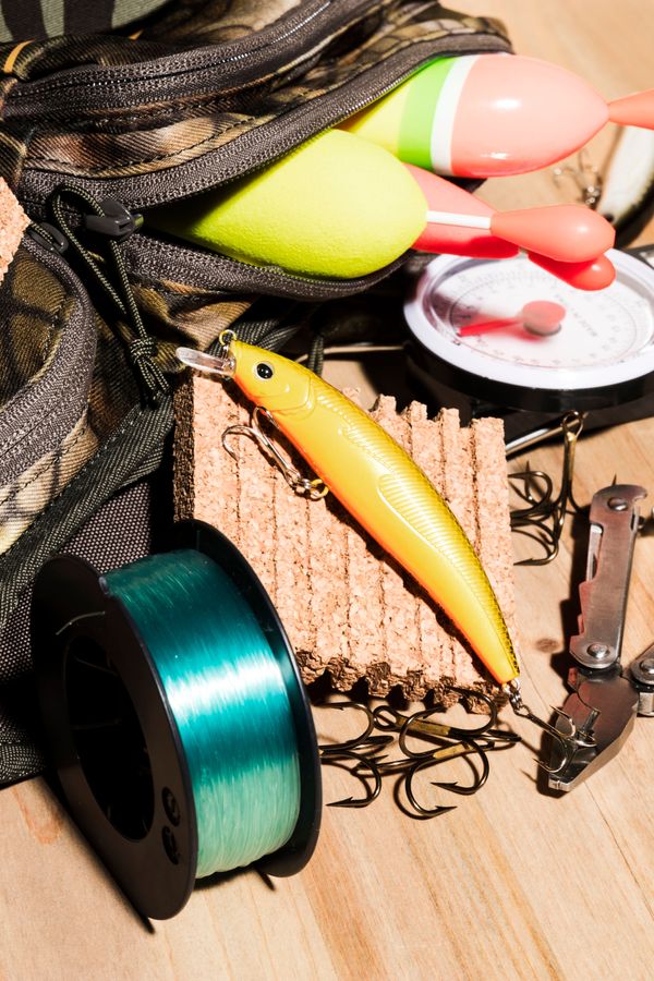 buoy-bag-fishing-lure-fishing-reel-wooden-desk.jpg