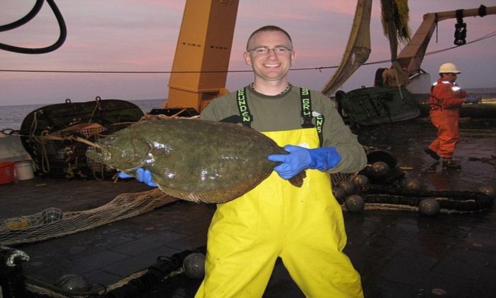 fisherman holding caught flounder