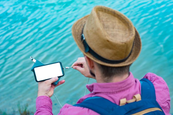 man-charges-smartphone-with-portable-charger-man-with-power-bank-his-hand-background-sea-bright-sunny-day-with-clouds.jpg