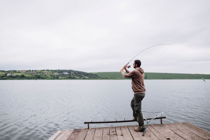 man-throwing-fishing-line-lake.jpg