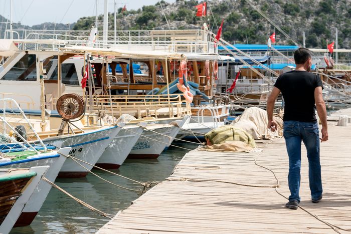man-walking-pier-near-moored-boats.jpg