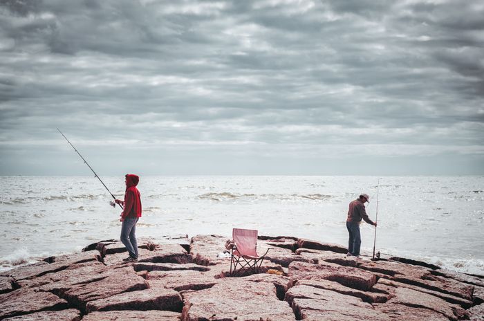 men-fishing-by-sea-against-cloudy-sky-sunny-day.jpg