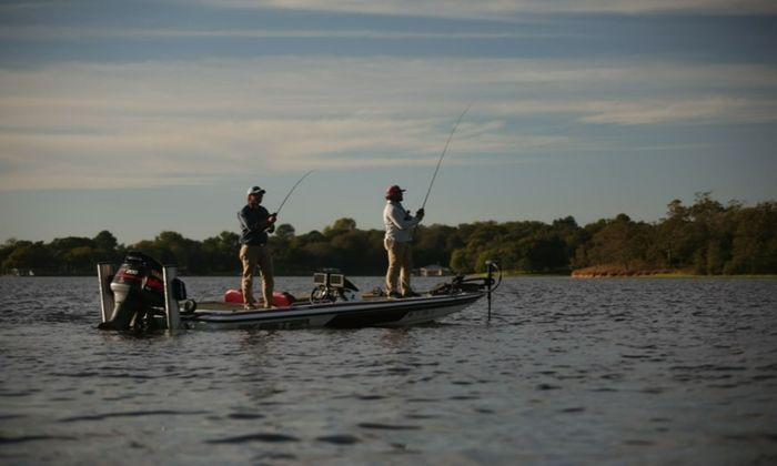 men standing on a boat fishing 