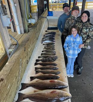 Smiling anglers and a table full of fish!