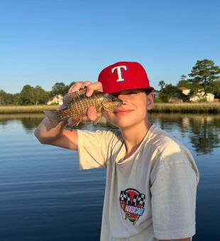 Exciting catch on the water — young angler showing off a feisty black bass!