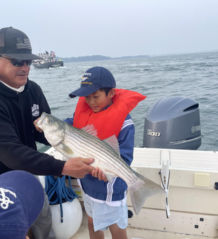 Big Striped Bass hooked while deep sea jigging in partly cloudy Hingham!
