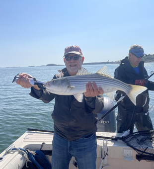 Nice striped bass using deep sea jigging and light tackle in partly cloudy conditions.