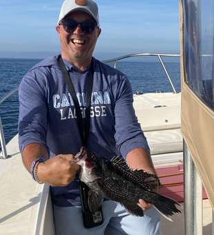 Reeling in a sea bass on a partly cloudy day with storms brewing!