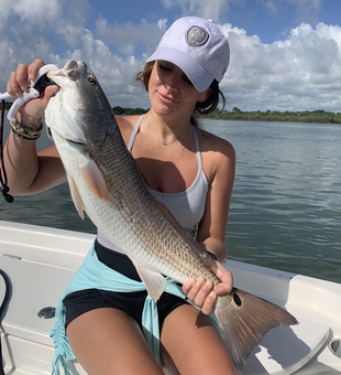 Light tackle triumph: Reeling in a redfish under partly cloudy skies!