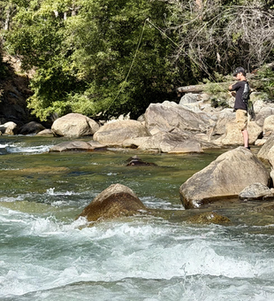 Kings River fly fishing among boulders and flowing water.