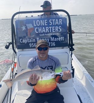 Reeling in trophy redfish in the shallow waters of Lower Laguna Madre.