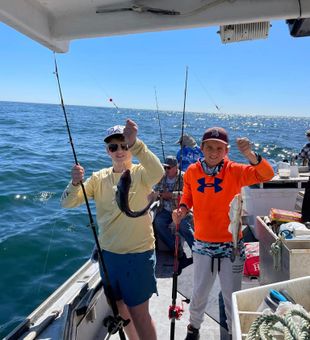 Two teenage anglers celebrating their catch.