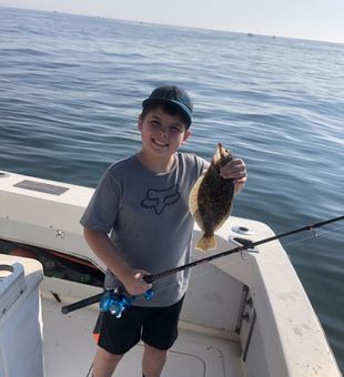 Proud fluke catch on New Jersey fishing trip.