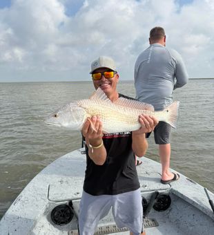 Smiling with a solid redfish catch.