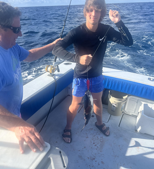 The angler battles a mystery catch with their heavy tackle in the choppy waters off West Palm Beach.
