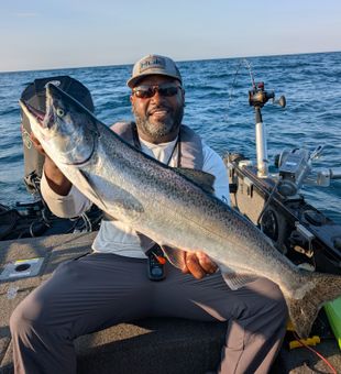 Big catch of the day! This angler proudly shows off a massive salmon aboard a fishing boat.