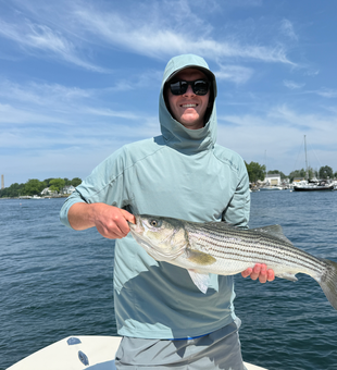 Striped Bass on the line in Portsmouth's partly cloudy waters!