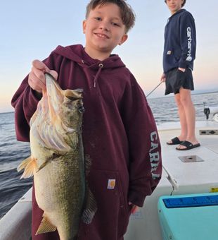 Proud young angler with a chunky largemouth bass on a family fishing trip