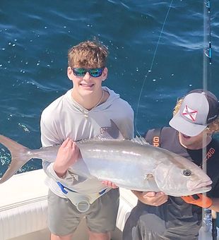 Solid amberjack catch with a proud smile on deck.