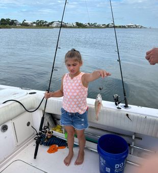 Little angler’s tiny catch, big smile!
