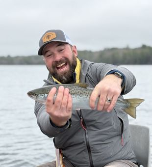 Happy angler with a beautiful Salmon catch on the lake!