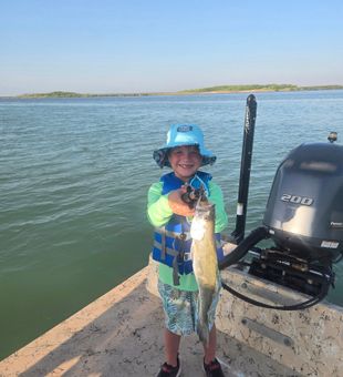 Proud young angler raises his trout catch - South Padre Island, TX.