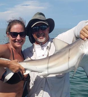 Vibrant shark catch with happy anglers.