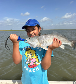 Reeling in a redfish while deep sea jigging under clear Matagorda skies!