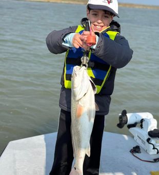 Proud young angler with a hefty redfish catch!