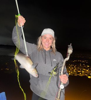 Orange nighttime fishing success with lights dancing on water!