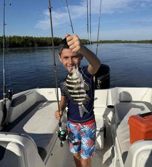 Young angler showing off a solid Sheepshead catch on a fun fishing trip!