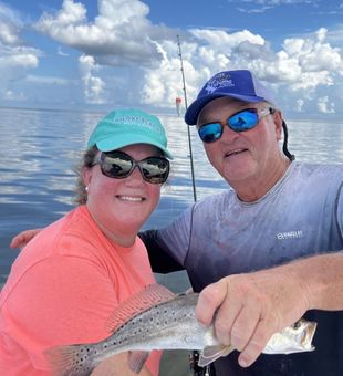 Smiling catch with Speckled Trout in coastal water
