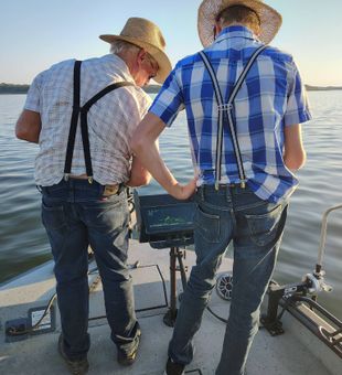 Focused anglers checking the fish finder on Truman Lake.