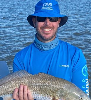 Smiling angler with a Port O’Connor Redfish catch