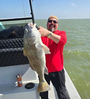 Smiles after hooking into a strong Corpus Christi redfish in the shallow bay waters.