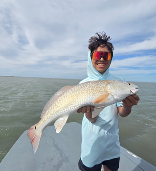Reeling in a feisty Redfish in the sunny Port Aransas waters!