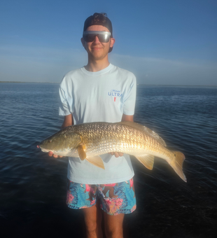 Huge 22-inch Redfish reeled in during a stormy Port Aransas adventure!