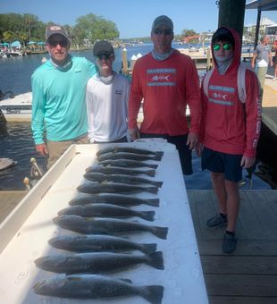 Fresh speckled trout catch with proud anglers.