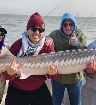 Reeling in a trophy sturgeon on a San Francisco, CA fishing charter.