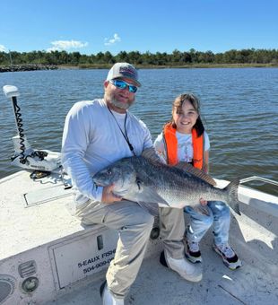 Smiles all around after landing a hefty Black Drum