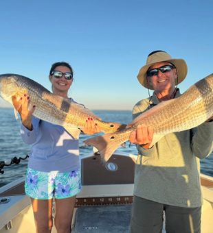 Lunker redfish duo at Cape Coral, golden hour on deck.