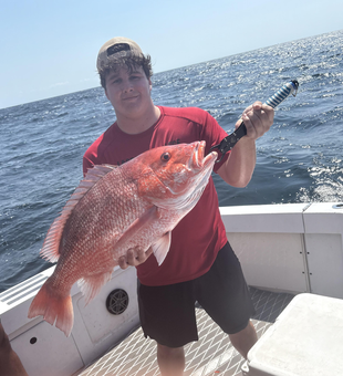 Reeling in the red with light tackle in Pensacola's clear skies!