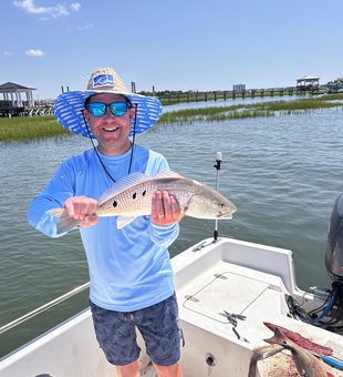 Reeling in a keeper redfish with light tackle on a clear day!