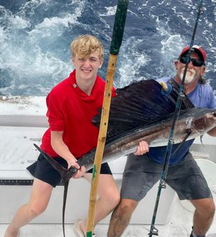 Giant sailfish catch with proud anglers on deck.
