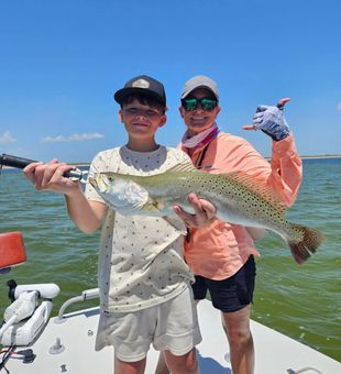 Big speckled trout, calm waters, solid catch.