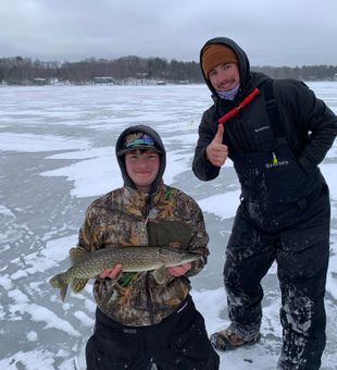 Solid ice fishing Northern Pike catch on frozen lake