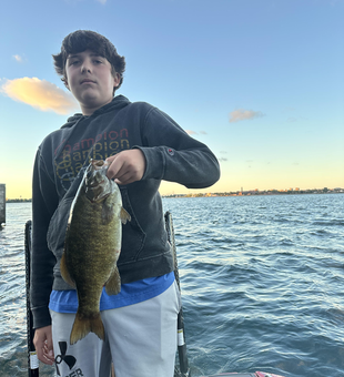 Nice smallmouth bass using drift fishing technique in partly cloudy conditions.
