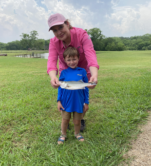 Big striped bass reeled in on a partly cloudy day with strong storms possible
